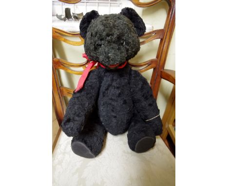 A vintage Austrian black astrakan teddy bear, approx. 20cm long.
