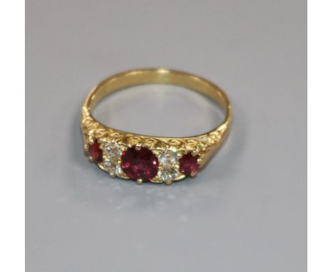 An early 20th century yellow metal, five stone ruby and diamond half hoop ring, size M.