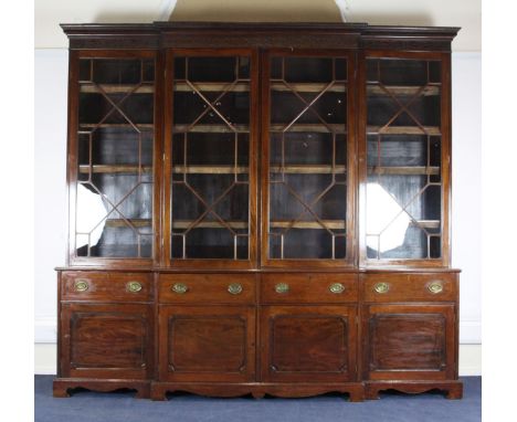 An Edwardian George III style mahogany breakfront library bookcase, with dentil cornice, blind fret carved frieze and four gl