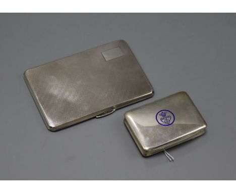 An engine-turned silver cigarette case and a small Continental cigarette case with blue enamel insignia.