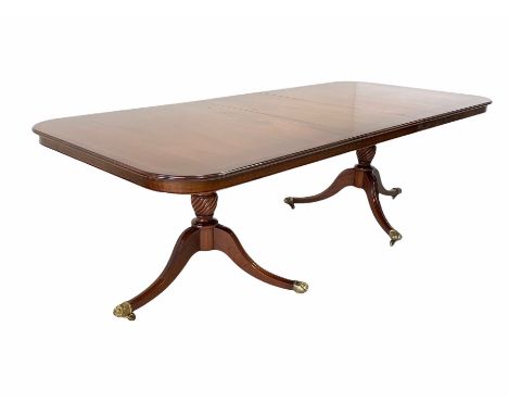 Regency design mahogany twin pillar dining table, the top with inlaid satinwood band over two turned columns with triple spla