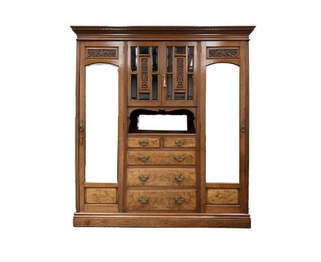 Late Victorian walnut wardrobe, broken arch pediment and dentil cornice over bevel glazed millinery cupboard with floral carv