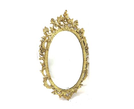 Ornate gilt framed oval wall mirror with floral scrolled decoration 57cm x 97cm