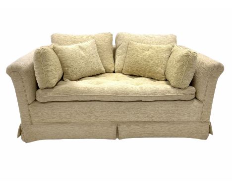 Two seat sofa upholstered in beige fabric, loose cushions, raised on castors, W147cm