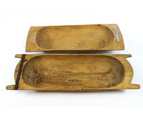 A wooden dough trough with two handled ends and later metal repairs, 113cm x 38cm