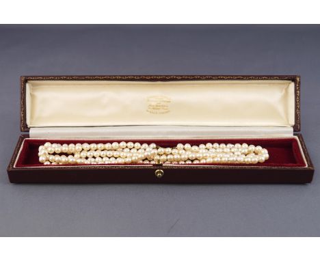 A three row cultured pearl (untested) necklace, strung plain and finished with a yellow gold cluster clasp set with opal and 