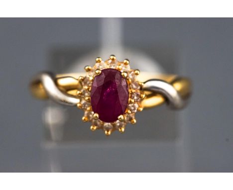 A yellow and white metal cluster ring set with an oval faceted cut ruby and surrounded by single cut diamonds. Untested - sta