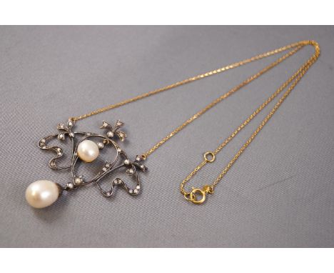 A yellow and white metal centrepiece necklace, grain set with round cut diamonds and finished with freshwater pearls. Suspend