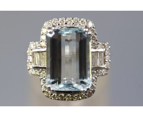 A white metal cluster ring set with a rectangular cut aquamarine of approximately 6.74cts, further set with round brilliant c