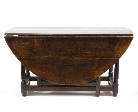 An 18th century oak oval gate leg table on turned legs, 136cm x 155cm