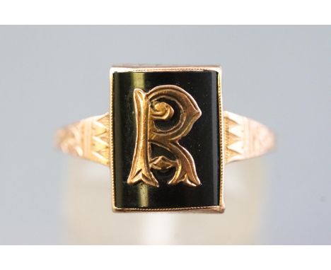 A yellow metal Masonic signet ring set with black onyx and embellished with an R initial, stamped 9ct. Size: M 2.4 grams 