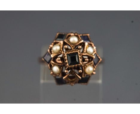 A yellow metal dress ring set with commercial quality sapphires and seed pearls. No hallmark - tests indicate gold of approxi