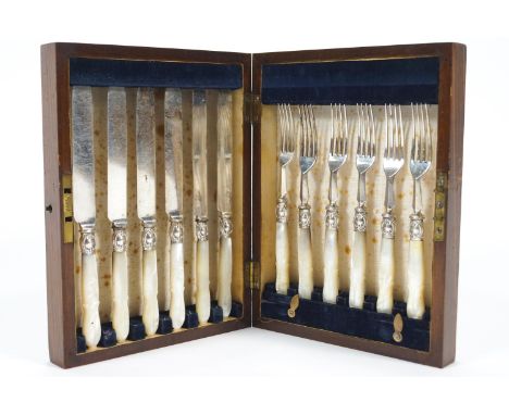 An oak cased set of close plated fruit knives and forks with carved mother of pearl handles, the knives 20cm long
