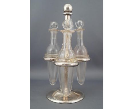 A silver three bottle cruet stand with ring slots for three collared plain glass vials, on a domed foot, London 1851, 19cm hi