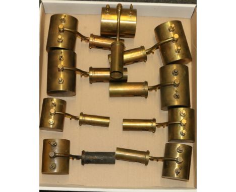 Nine brass paraffin blow lamps built by Peter Russell Aitken.&nbsp;Peter Russell Aitken, on plinth 59cm long.&nbsp;Peter Russ