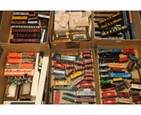 OO gauge model railways within six trays including coaches, wagons, vans and rolling stock, Hornby, Mainline etc, some boxed&