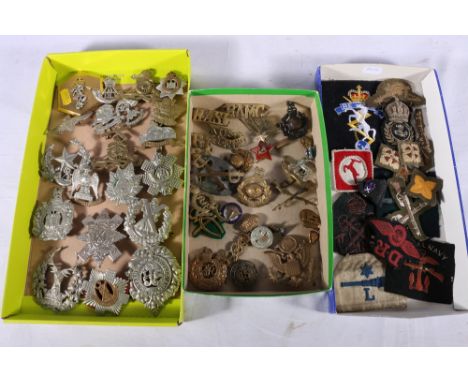 A collection of around 60 military cap badges, buttons, cloths, shoulder titles etc. including King's Own Scottish Borderers,