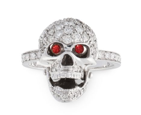 A DIAMOND AND ORANGE SAPPHIRE SKULL RING in 18ct white gold, designed as a skull, pave set with round cut diamonds, with an a
