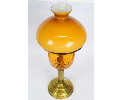 Victorian oil lamp with amber coloured reservoir and amber shade