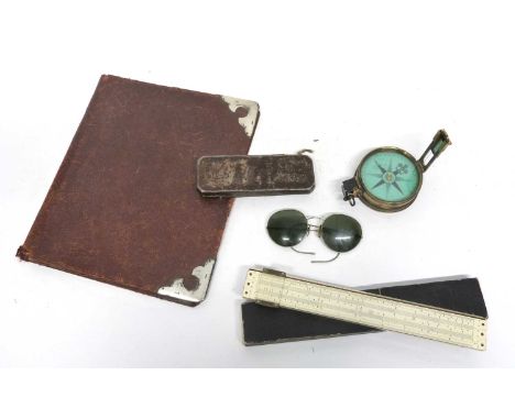 A navigators compass in brass case with slide rule in orginal case, wire rimmed sunglasses, leather folder with silver corner