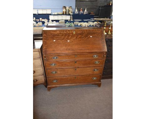 George III oak bureau of typical form, the full front opening to an interior with pigeon holes and small drawers over a base 