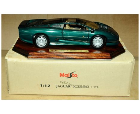 Maisto 1/12th Scale Jaguar XJ220. Finished in metallic green &amp; mounted on a wooden display plinth. Condition: Excellent P