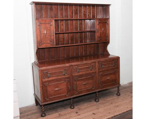 1920's oak dresser with shelf and cabinet back standing on base fitted 3 drawers and 3 cupboards with barley twist legs 66" w