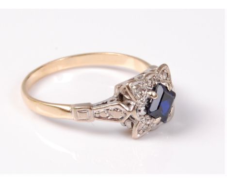 A synthetic sapphire and diamond ring, the step cut sapphire surrounded by small round brilliant cut diamonds in an overall s