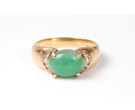 A jade and diamond ring, the oval jade cabochon, approx. 10x7.6mm, set to either side with five small round brilliant cut dia