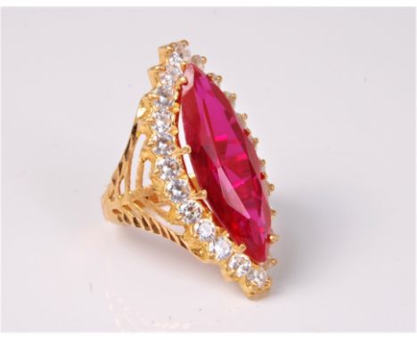 A synthetic ruby and white hardstone ring, navette shaped ruby, 2.5cm long,  surrounded by round white hardstones, all claw s