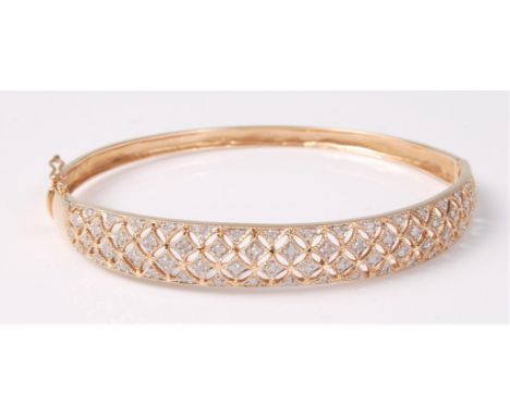 A 9ct diamond bangle, the tapering bangle, approx. 8.4mm wide, a pierced fretwork set with small round brilliant cut diamonds