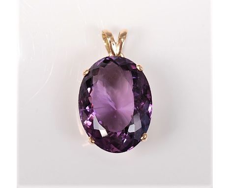 An amethyst pendant, the oval mixed cut amethyst approx. 2.16 x 1.61cm, in a four claw mount and pierced gallery, with bifurc