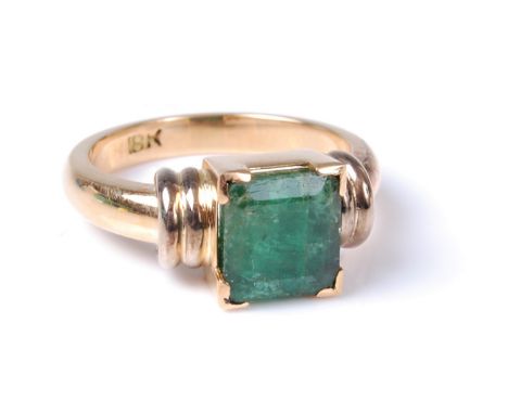 An emerald ring, the step cut emerald, approx. 8 x 7.5mm, in a four corner claw mount, with banded shoulders and plain band s