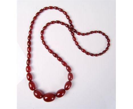 A faux 'cherry amber' necklace, the oval graduated beads between approx. 2.1cm - 7.1cm diameter, 84cm long   Condition Report