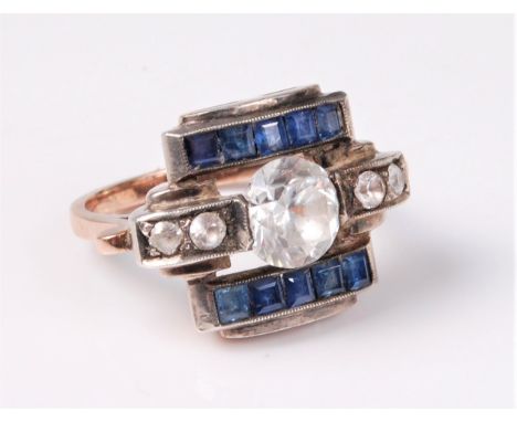 An Odeonesque white and blue sapphire ring, the central round white sapphire, approx. 7.7mm diameter, set to either side with