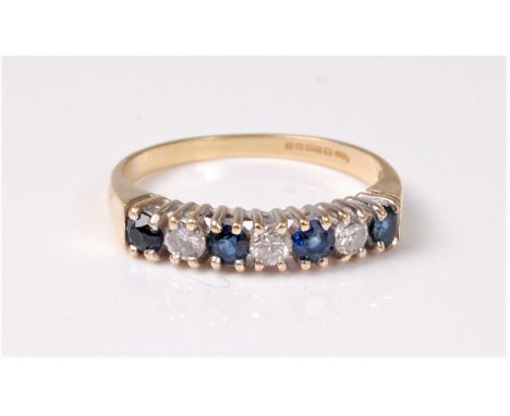 An 18ct sapphire and diamond ring, the seven small round alternating sapphires and diamonds, claw set in a single row to a pl