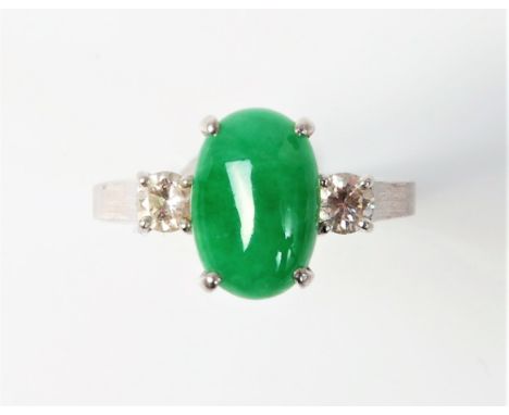 A jade and diamond ring, the oval jade cabochon approx. 10.6x7.1mm, set to either side with a single round brilliant cut diam