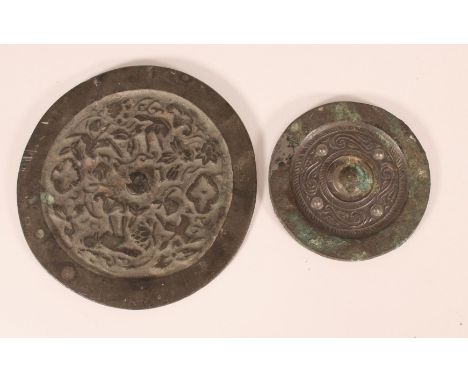 Chinese disc form bronze mirror, cast in relief with animals and foliage, W14cm, with another smaller mirror (2)