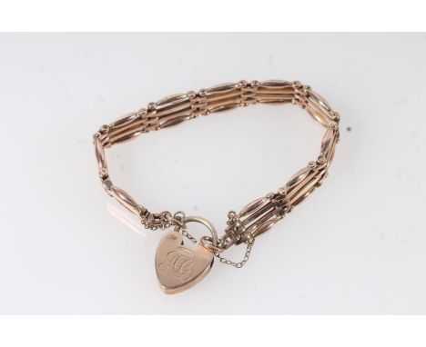 Edwardian yellow metal gate link bracelet with a 9ct gold heart shape clasp.