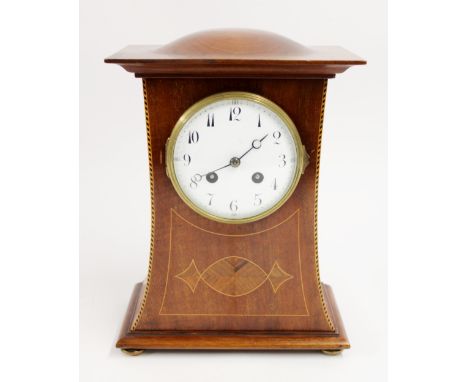 Edwardian mahogany mantel clock, the bulged top over an arching case on four brass feet, the white dial with arabic numerals 