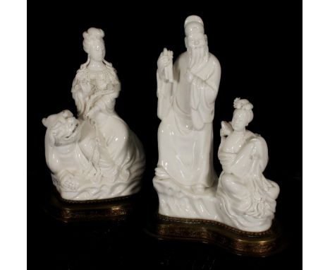 Chinese blanc de chine porcelain figurine of Guanyin seated on Denglong, together with another blanc de chine figural group, 