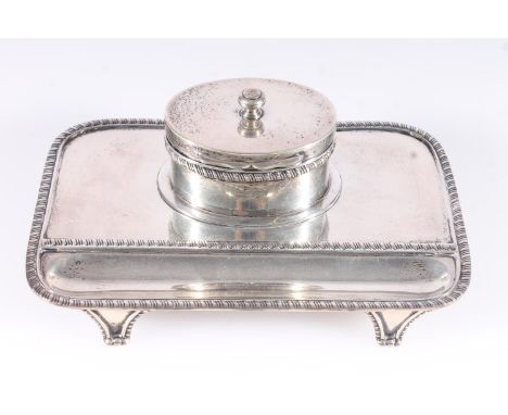 Geo.V silver inkstand, the rectangular stand with canted corners and gadrooned rims, recessed pen bed, raised on four gadroon