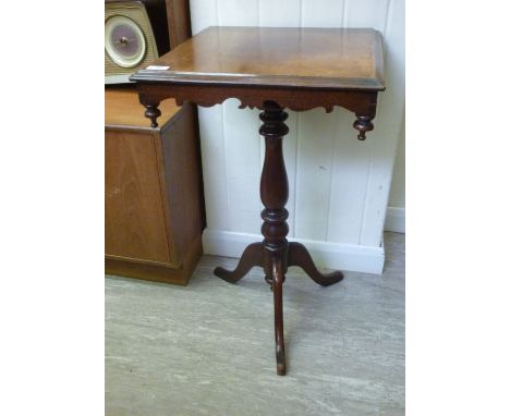 A late Victorian mahogany occasional table, the top having a carved apron, over a ring turned column and tripod, cabriole leg