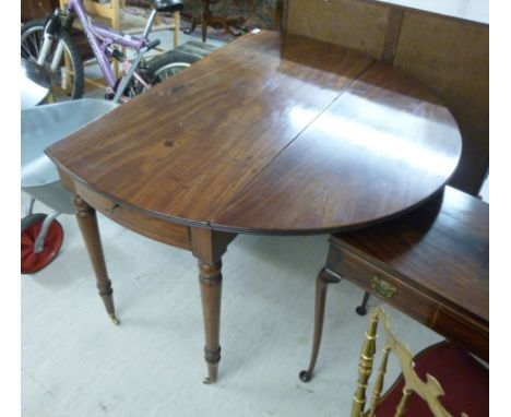 An early Victorian mahogany drop-leaf dining table, the top over a central drawer, raised on ring turned, tapered legs and ca