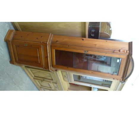 A modern pine corner cabinet, having glazed and panelled doors, raised on bracket feet  77''h  29''w       LSB