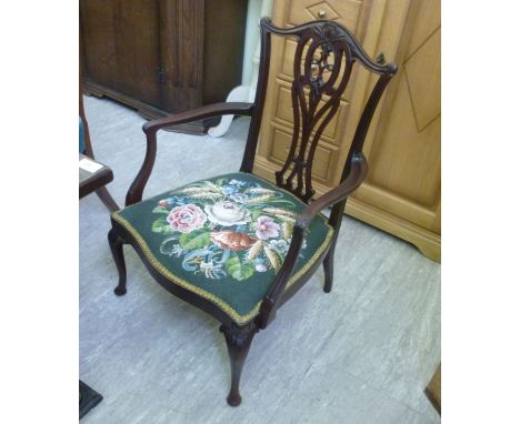 An Edwardian mahogany framed salon chair, having a vase shaped, pierced splat, over a tapestry upholstered seat, raised on ca