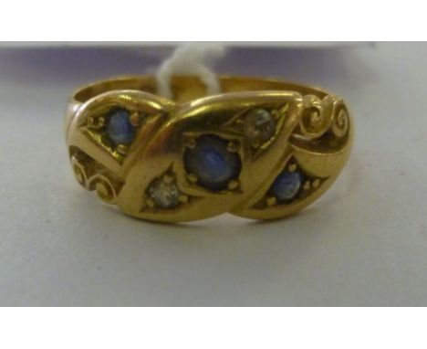 An 18ct gold sapphire and diamond set ring, having double C-scrolled ornament         11