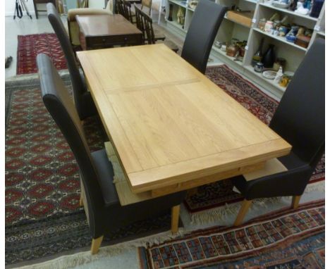 A modern light oak draw leaf dining table, raised on square, block legs  30''h  38''w  72''L extending to 98''L; and a set of