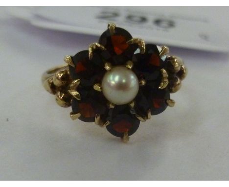 A 9ct gold ring, set with garnets and a central pearl       11