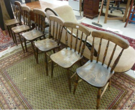 A matched set of six early 20thC stained beech and elm framed Windsor cottage style kitchen chairs, each having a curved cres